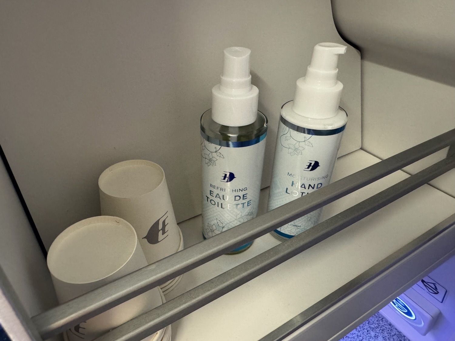 a group of bottles and cups on a shelf