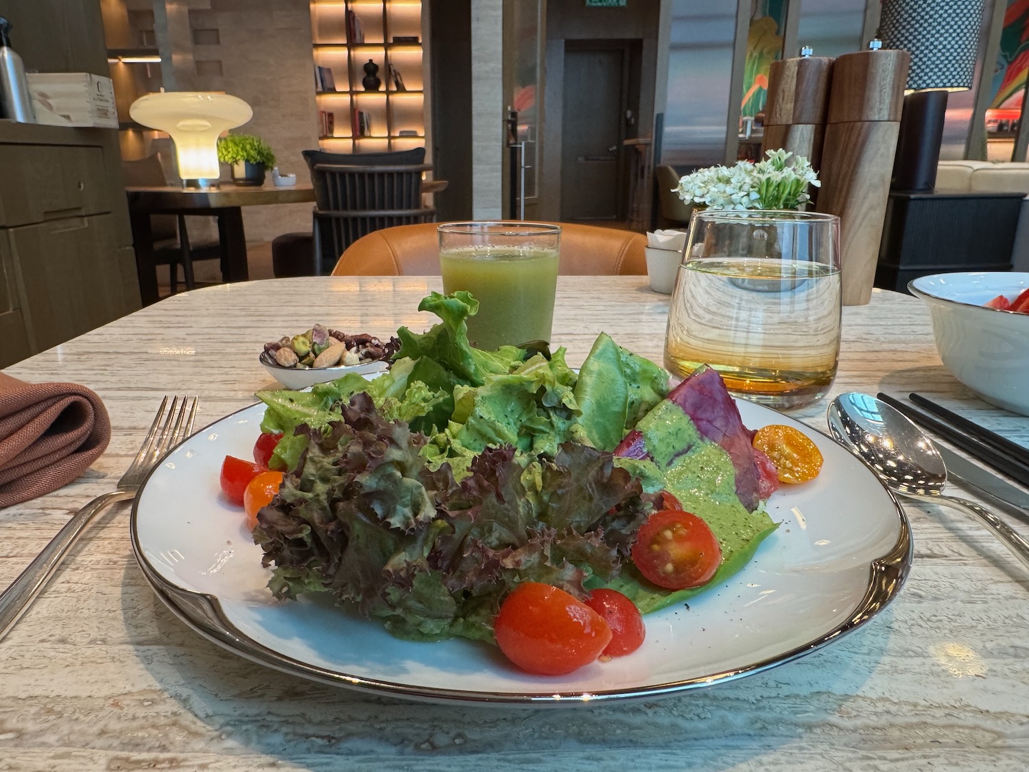 a plate of salad and a drink on a table
