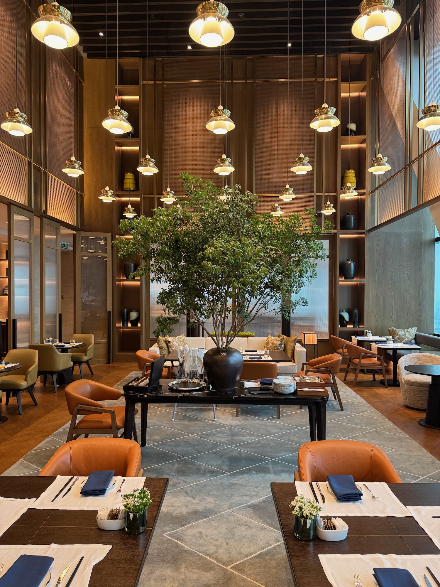 a room with tables and chairs and a tree