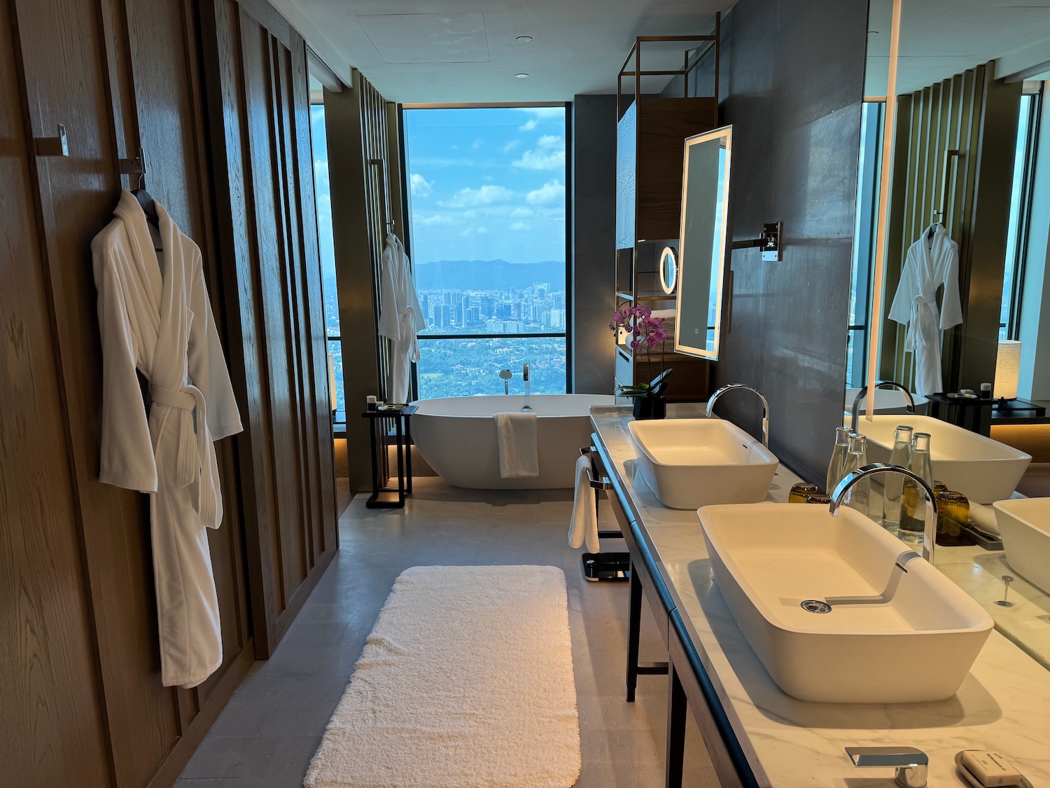 a bathroom with a large window and a view of a city