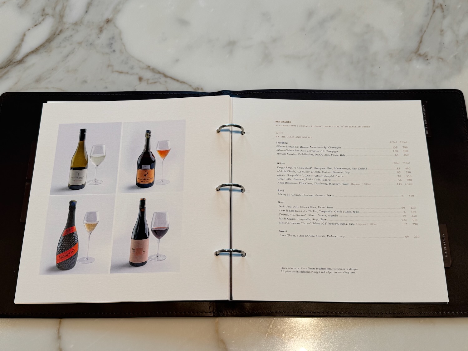a menu book with a picture of wine bottles and glasses