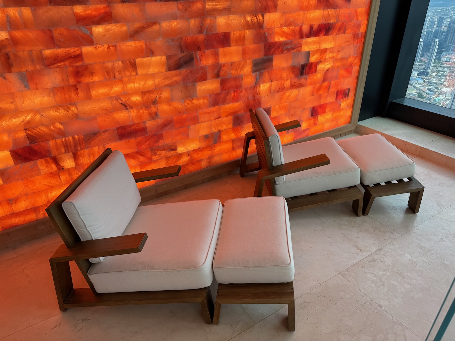 a two chairs and a bench in front of a wall