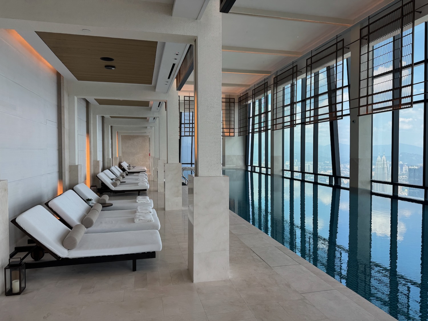 a pool with lounge chairs and a city view