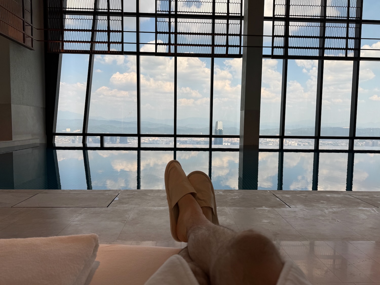 a person's legs in slippers on a bed