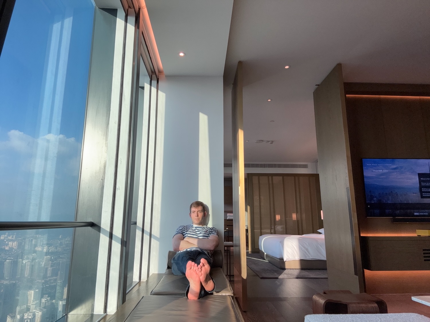 a man sitting on a bench in a room with a television