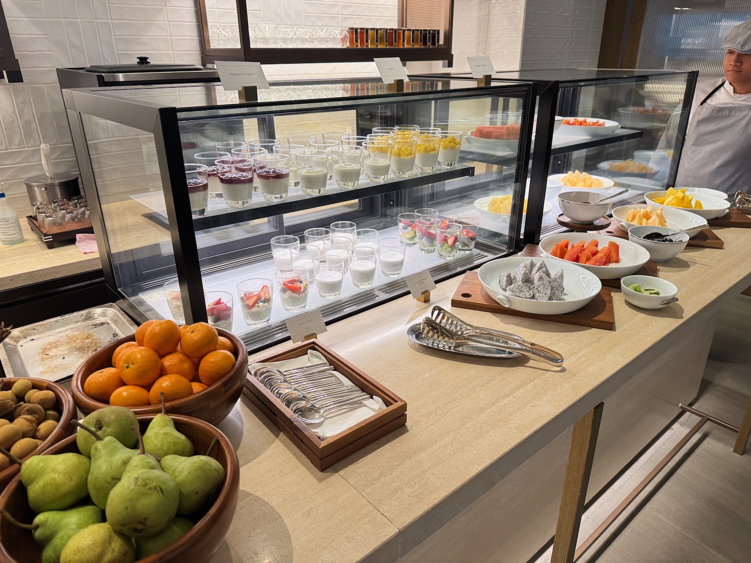 a display case with fruit and desserts