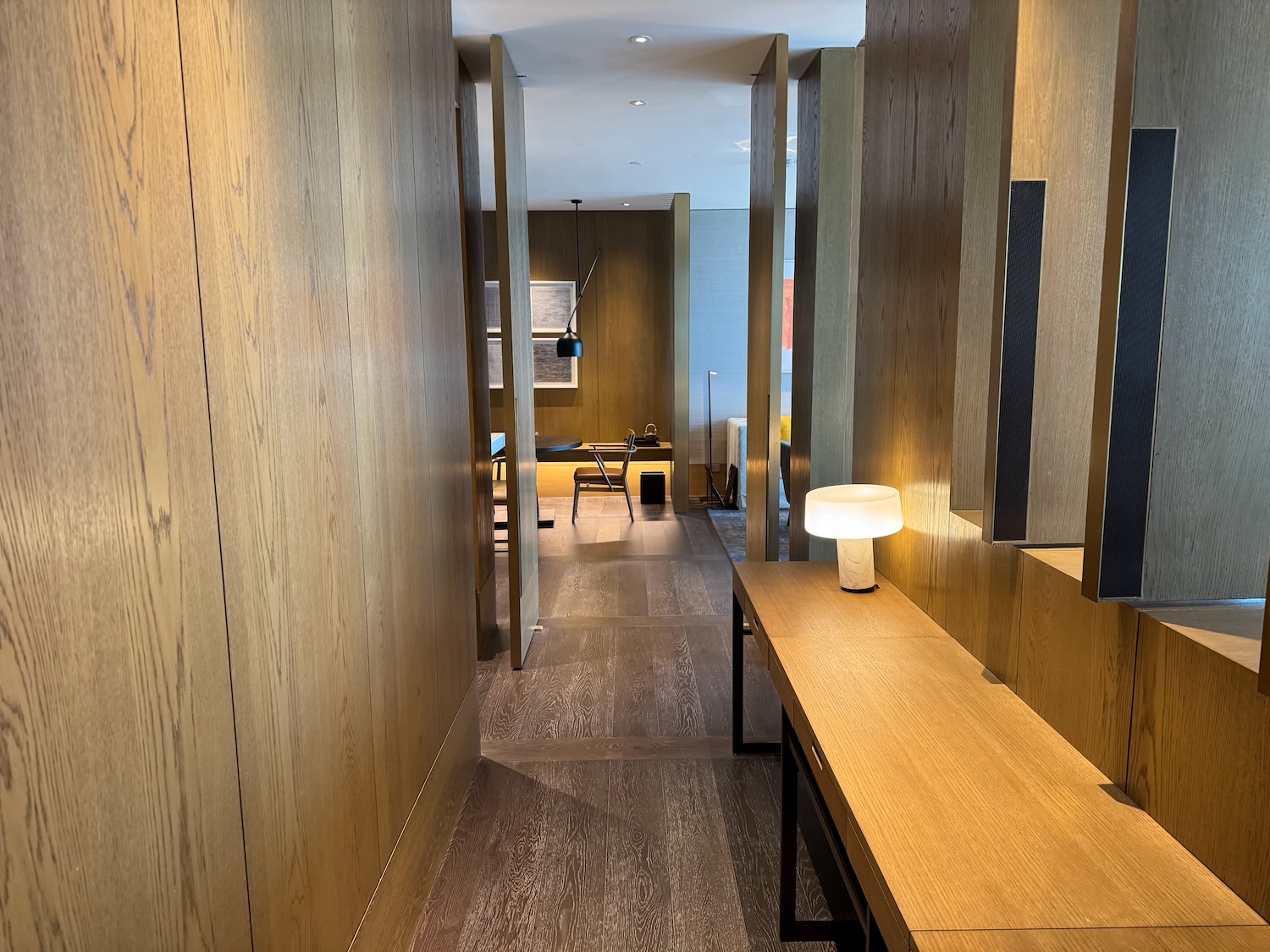 a hallway with a table and lamps