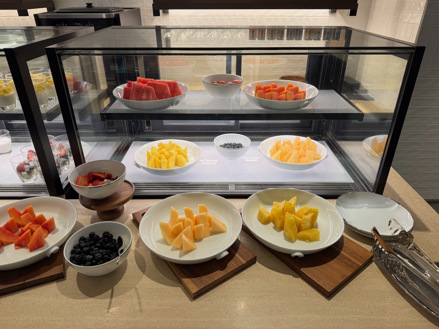 a display case with bowls of fruit