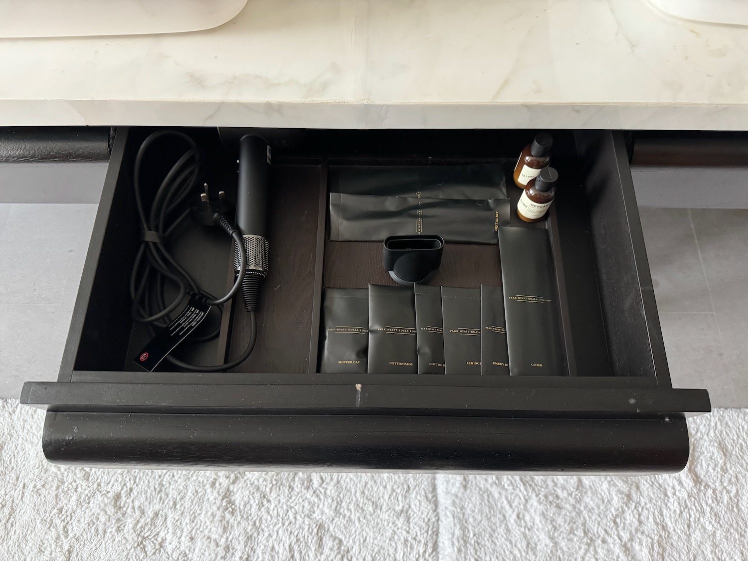 a drawer with a black tray and other items inside