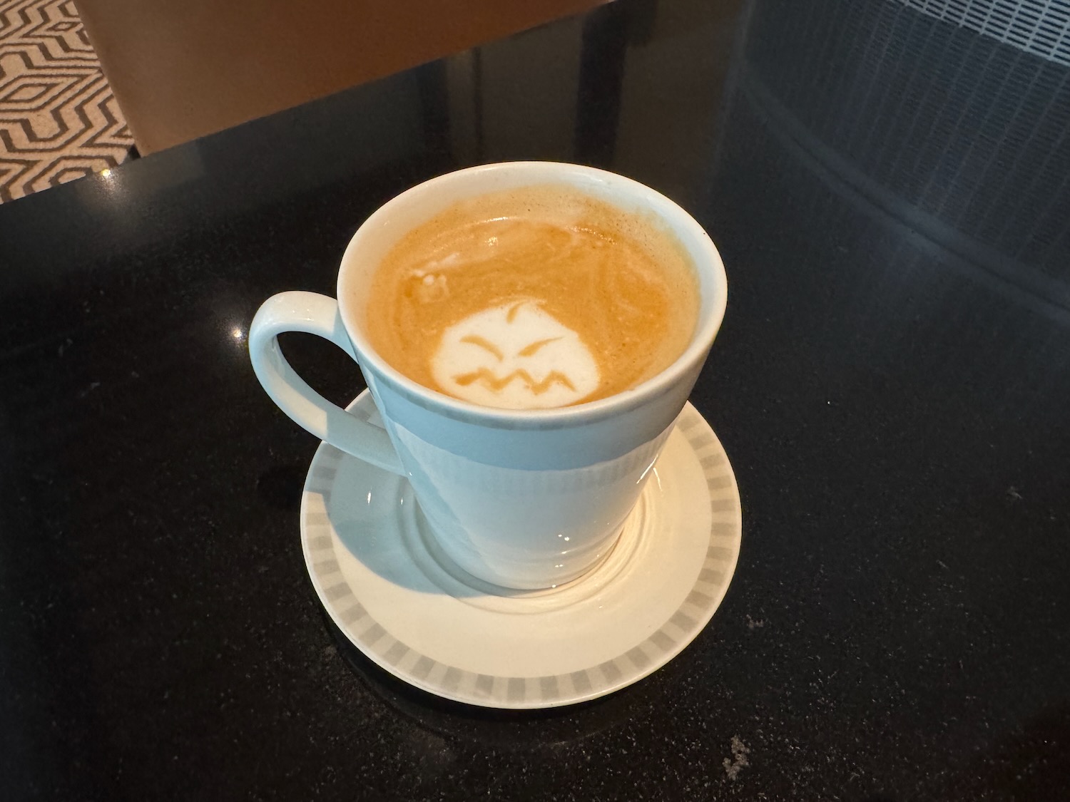 a cup of coffee with a face in the foam