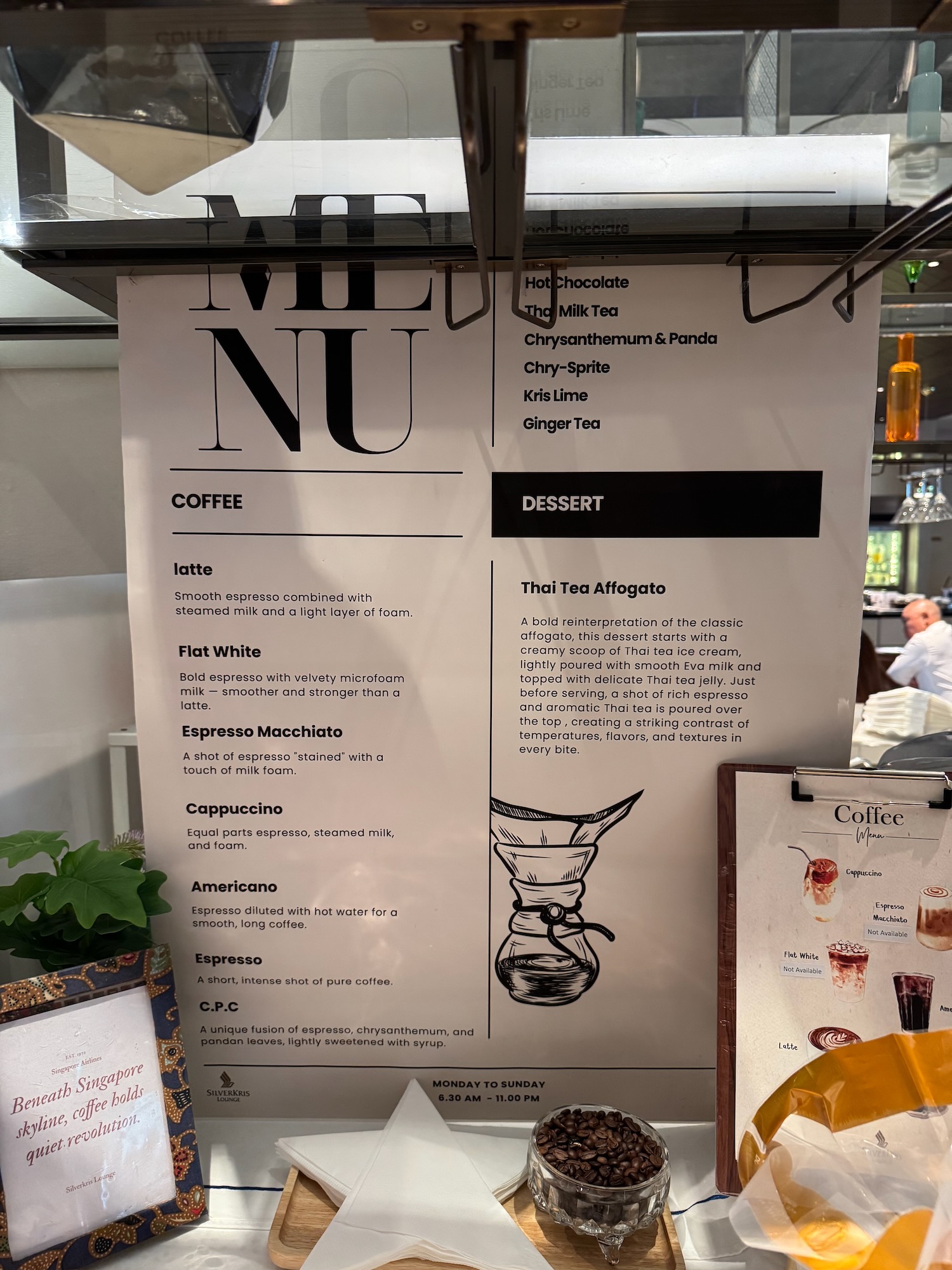 a menu sign with a picture of a coffee maker