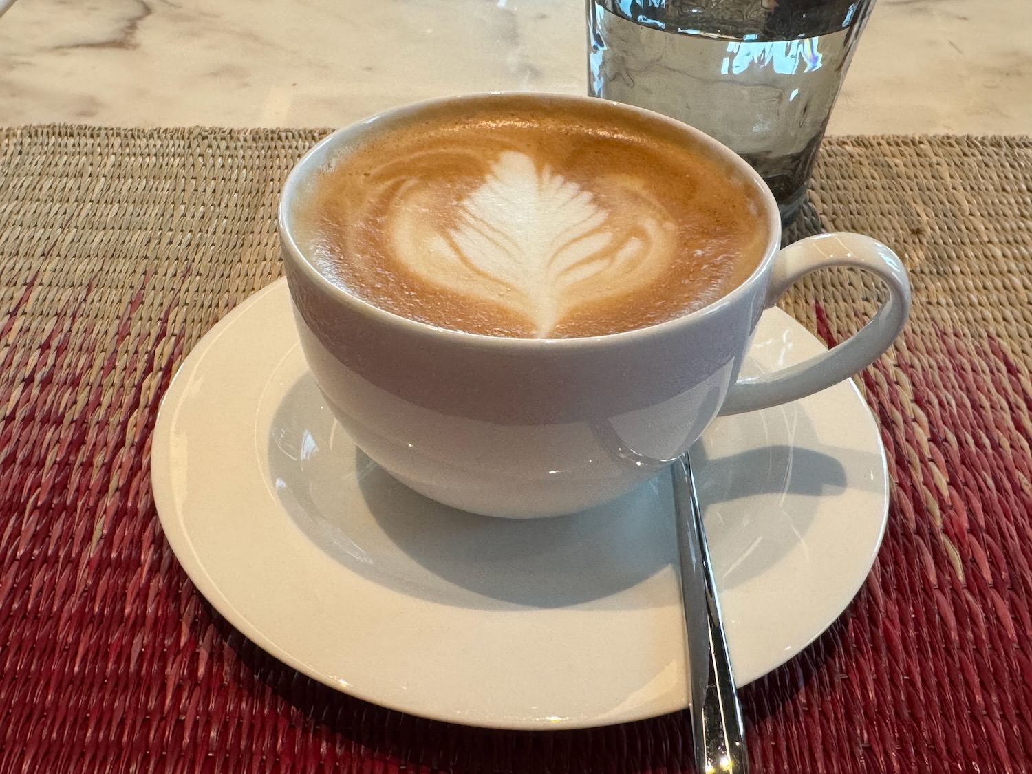 a cup of coffee with a leaf in the foam