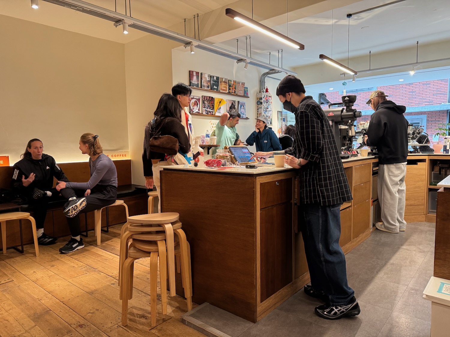 people standing at a counter in a coffee shop