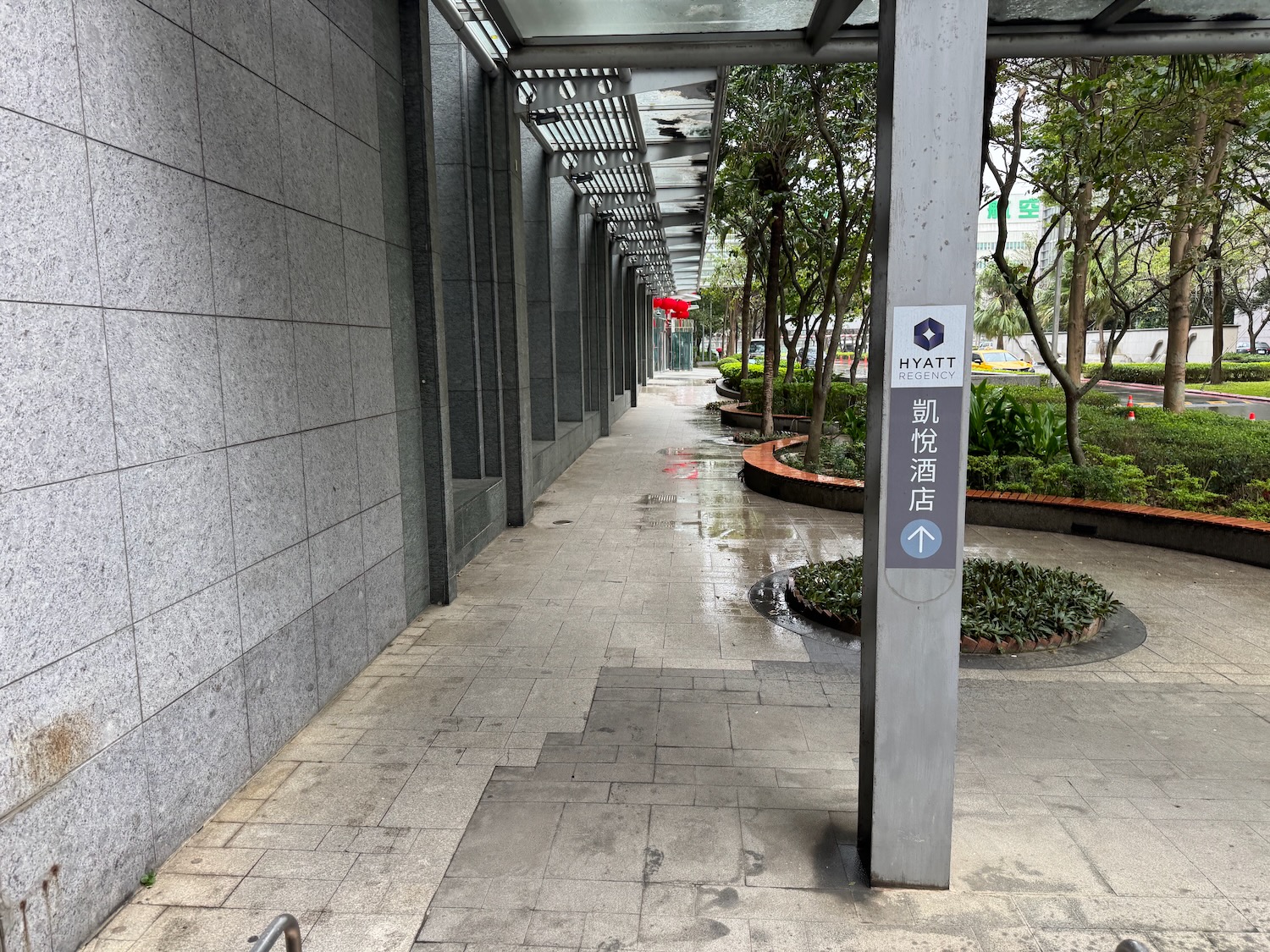 a walkway with a sign and trees