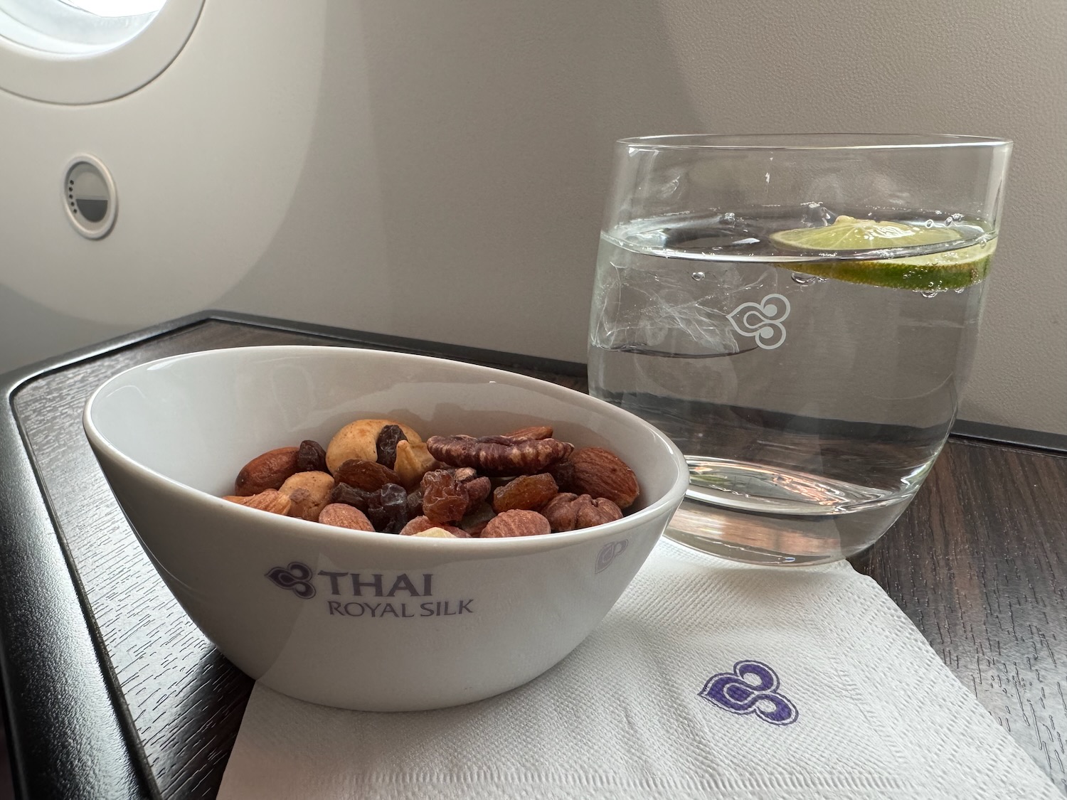 a bowl of nuts and a glass of water