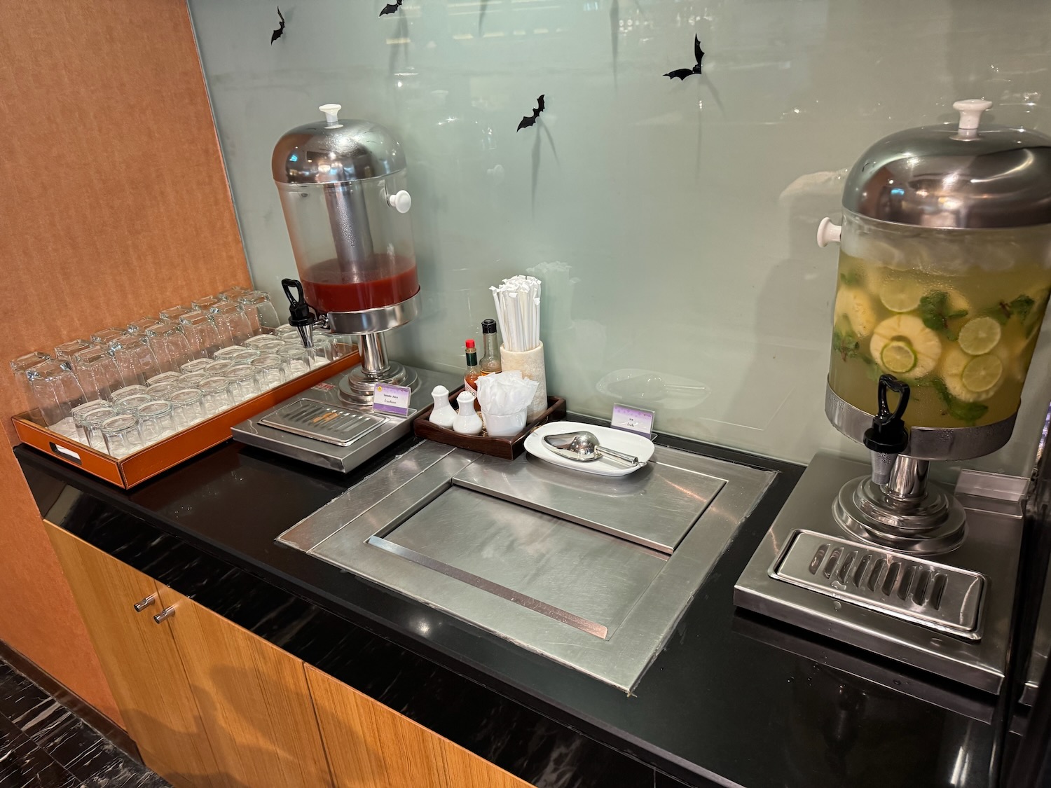 a counter with a drink dispenser and a drink dispenser