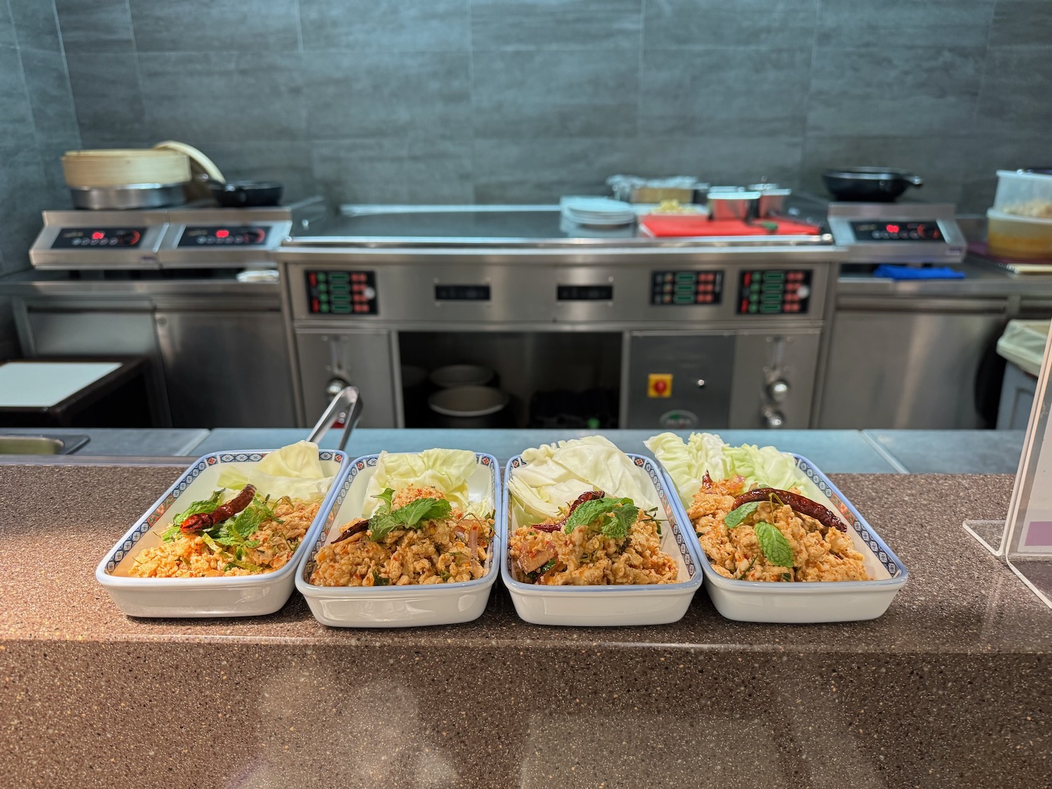 a row of containers of food in a kitchen