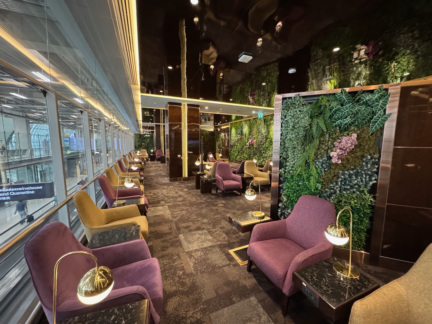 a room with chairs and a wall of plants