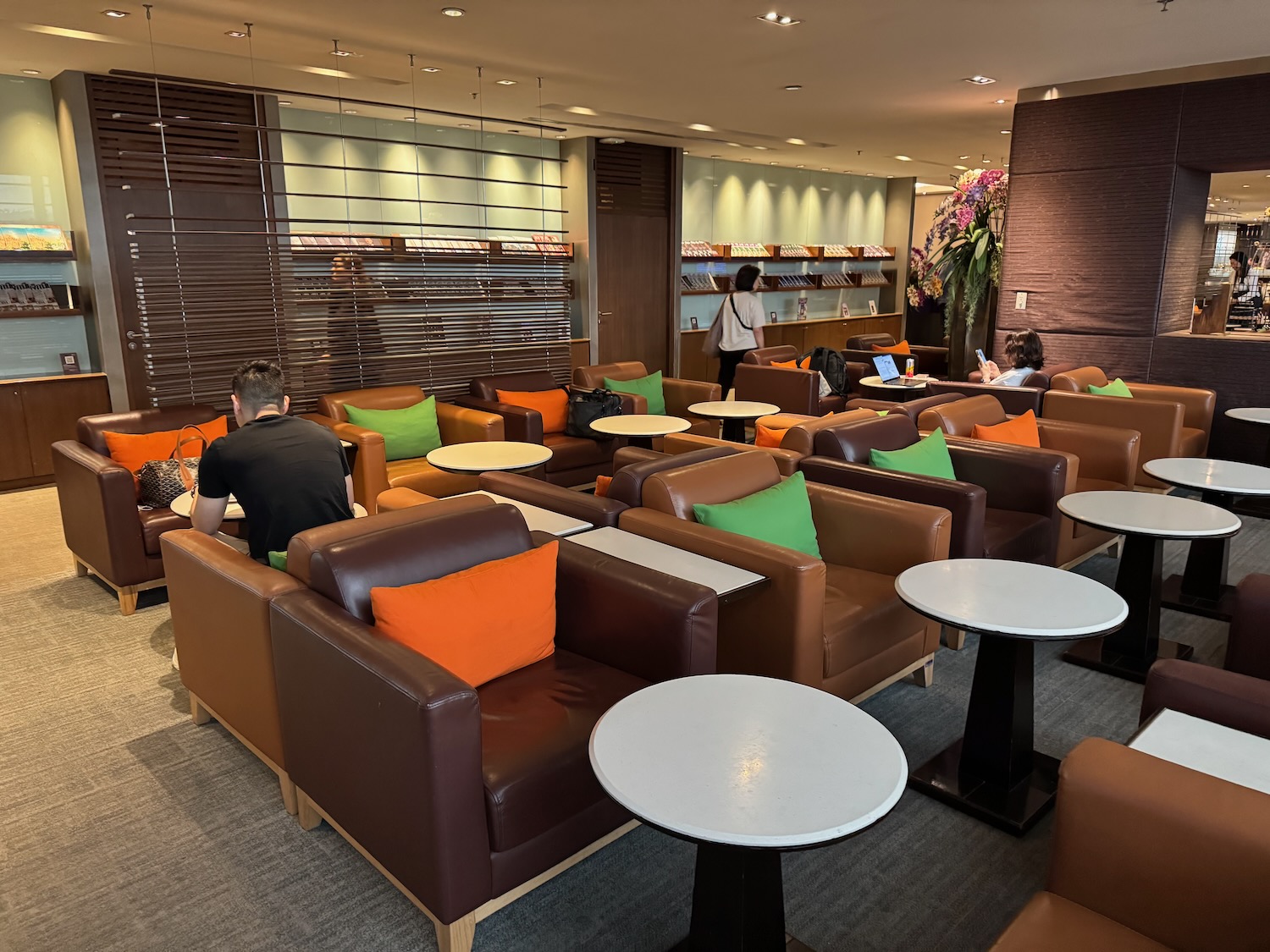 a group of people sitting in a room with chairs and tables