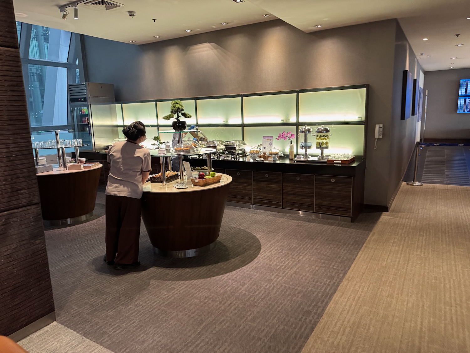 a woman standing at a counter in a room with food