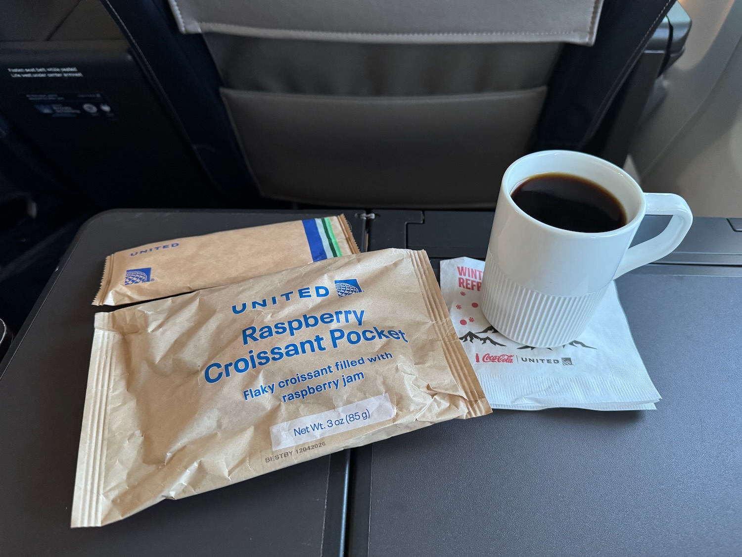 a cup of coffee and a packet on a table