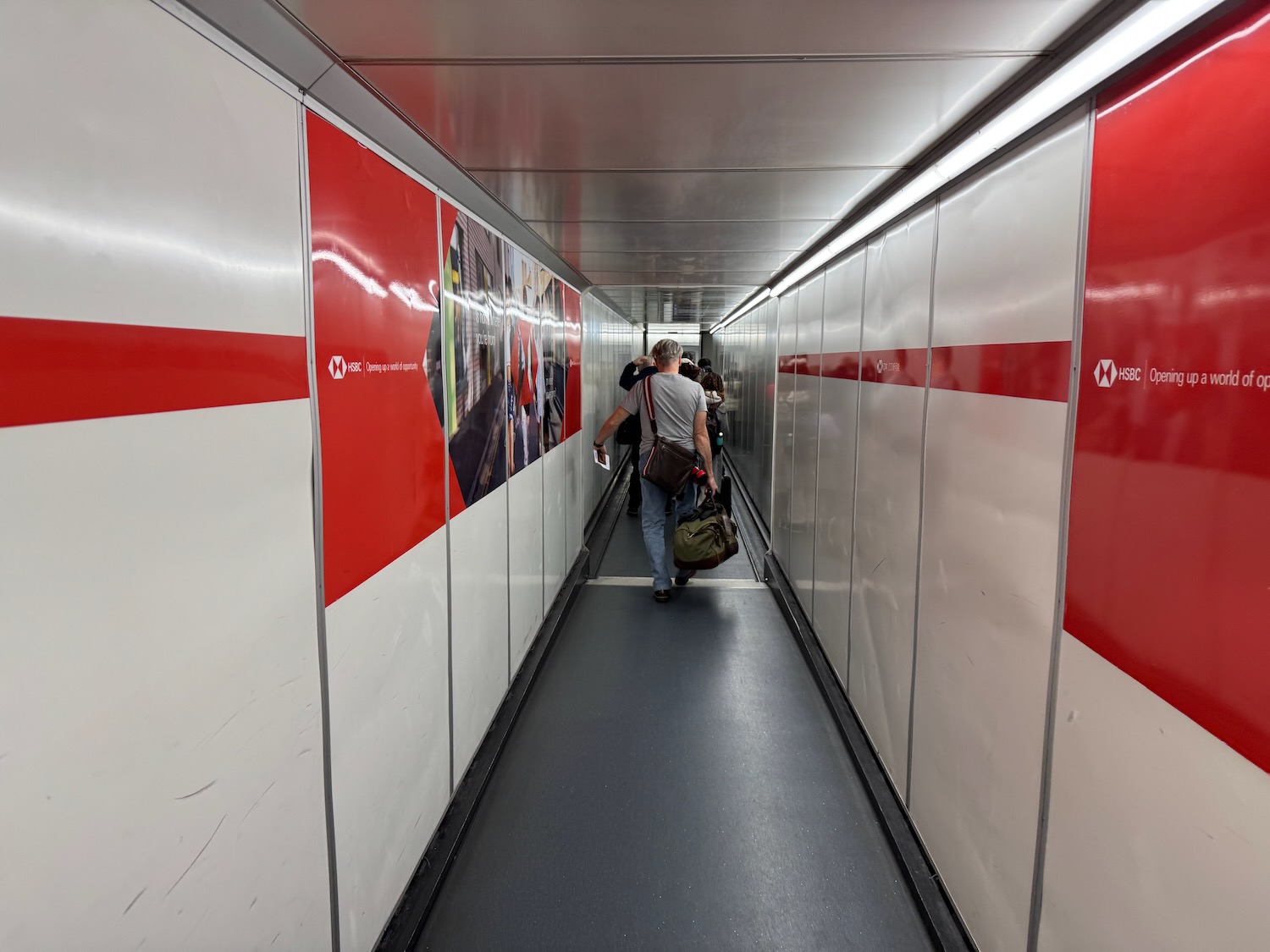 a man walking down a walkway with luggage