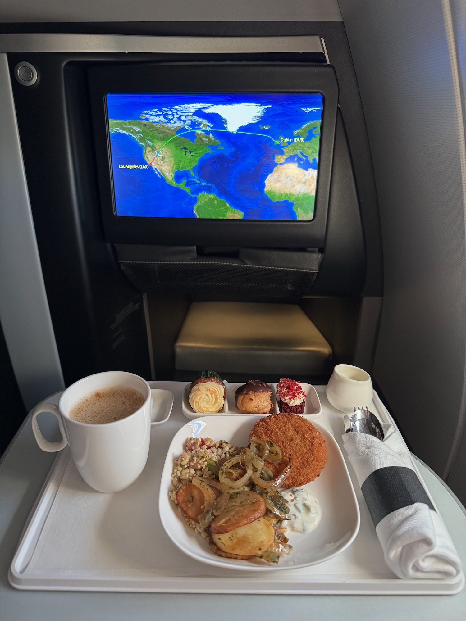a plate of food and a cup of coffee on a table with a television