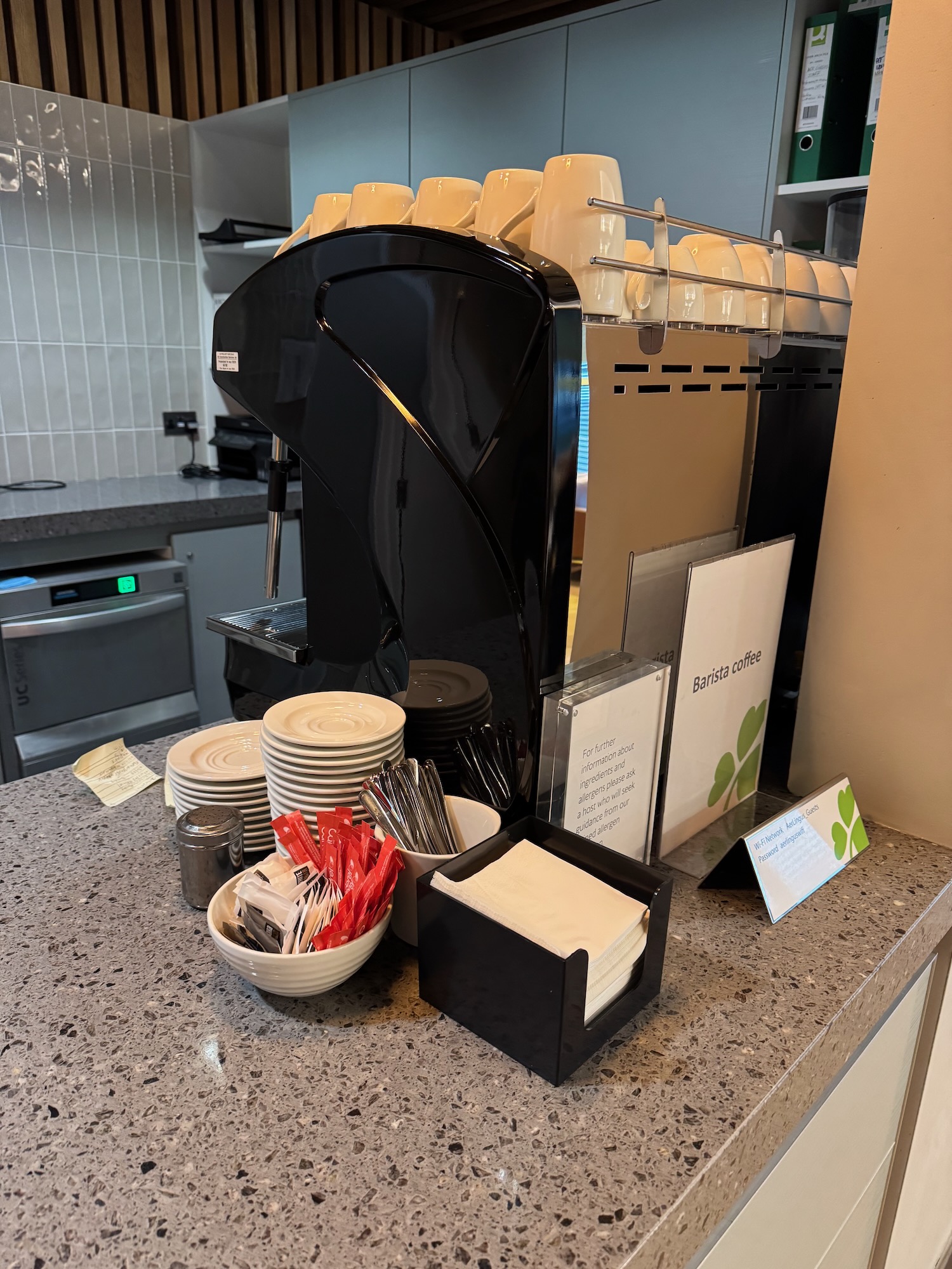 a coffee machine with a group of cups and plates on a counter