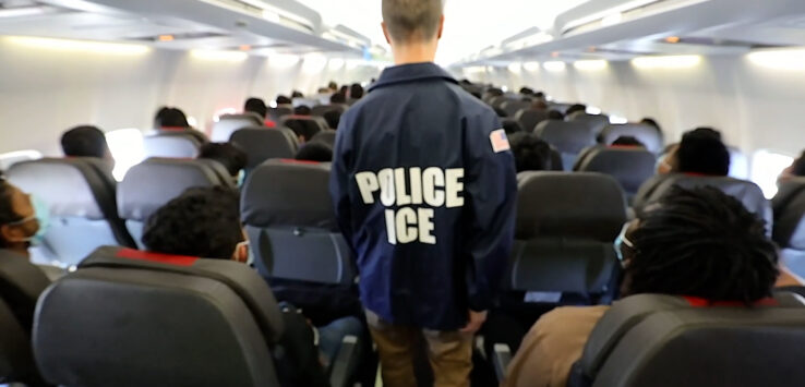a man in a blue jacket with white text on it