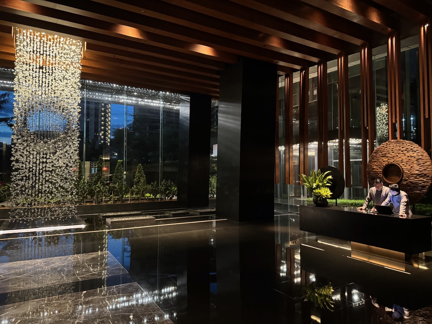 a lobby with a glass wall and a statue in it