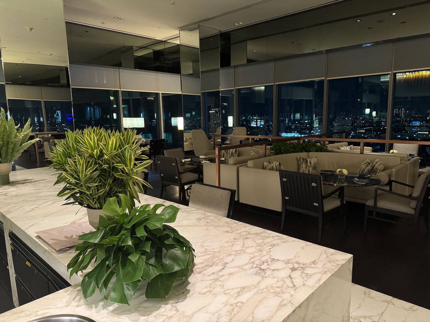 a room with a large window and a large table with plants