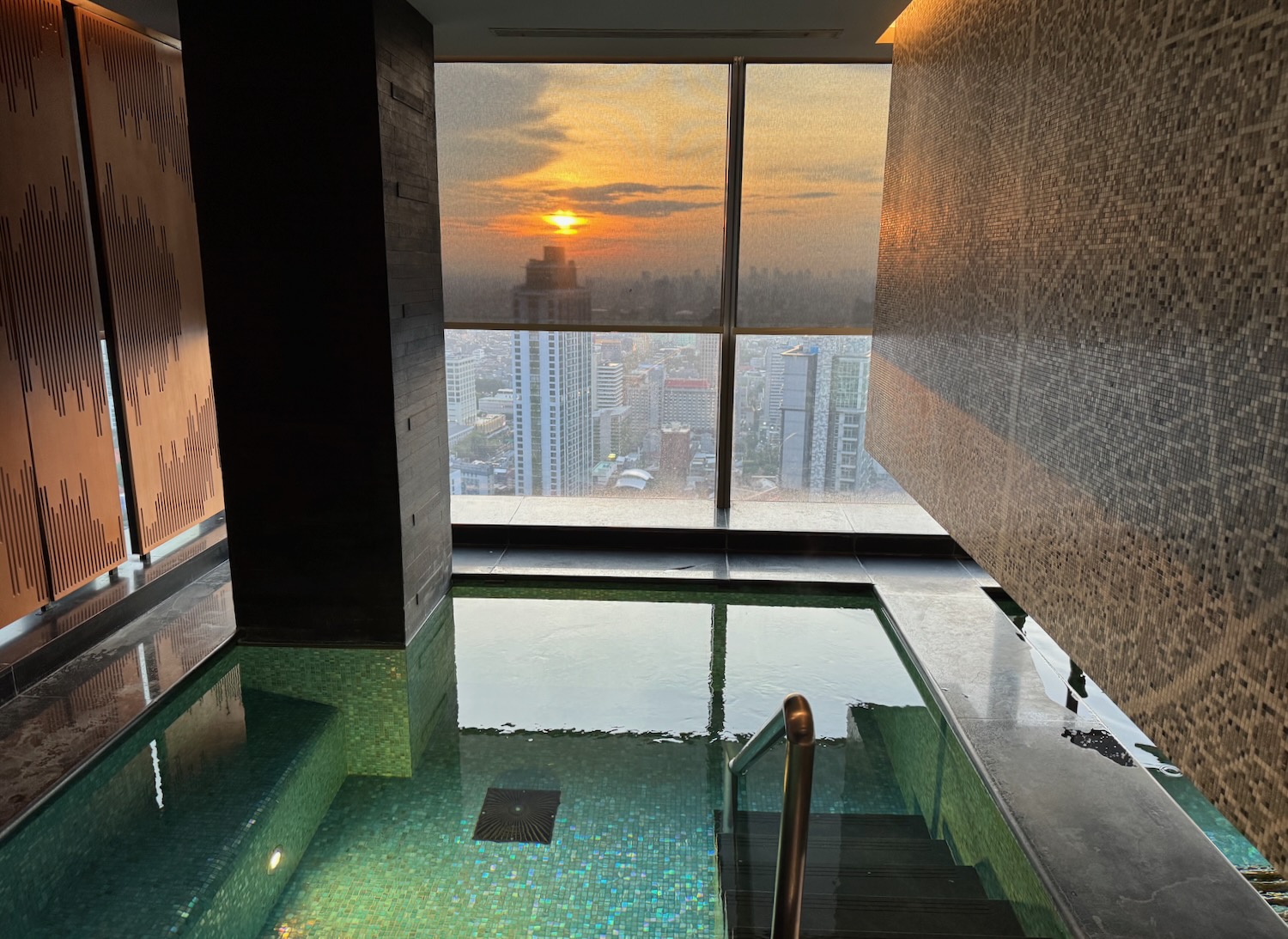 a pool with a staircase and a large window