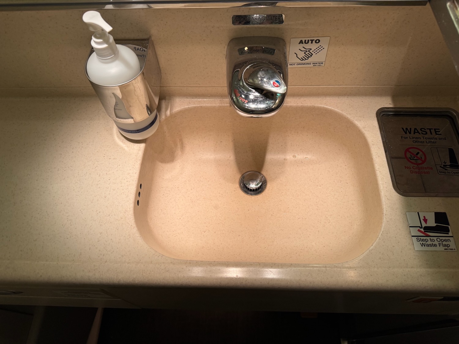 a sink with soap dispenser and a bottle of liquid