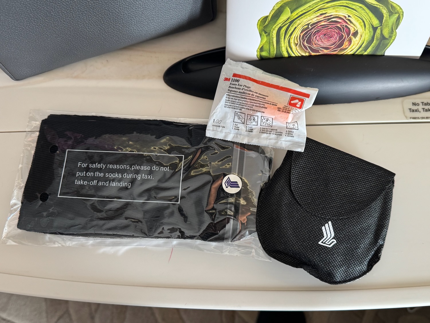 a black package with white text and a black bag on a white surface