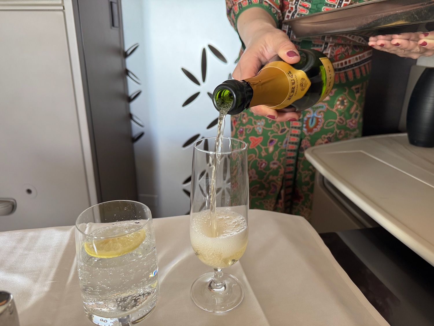 a person pouring a drink into a glass