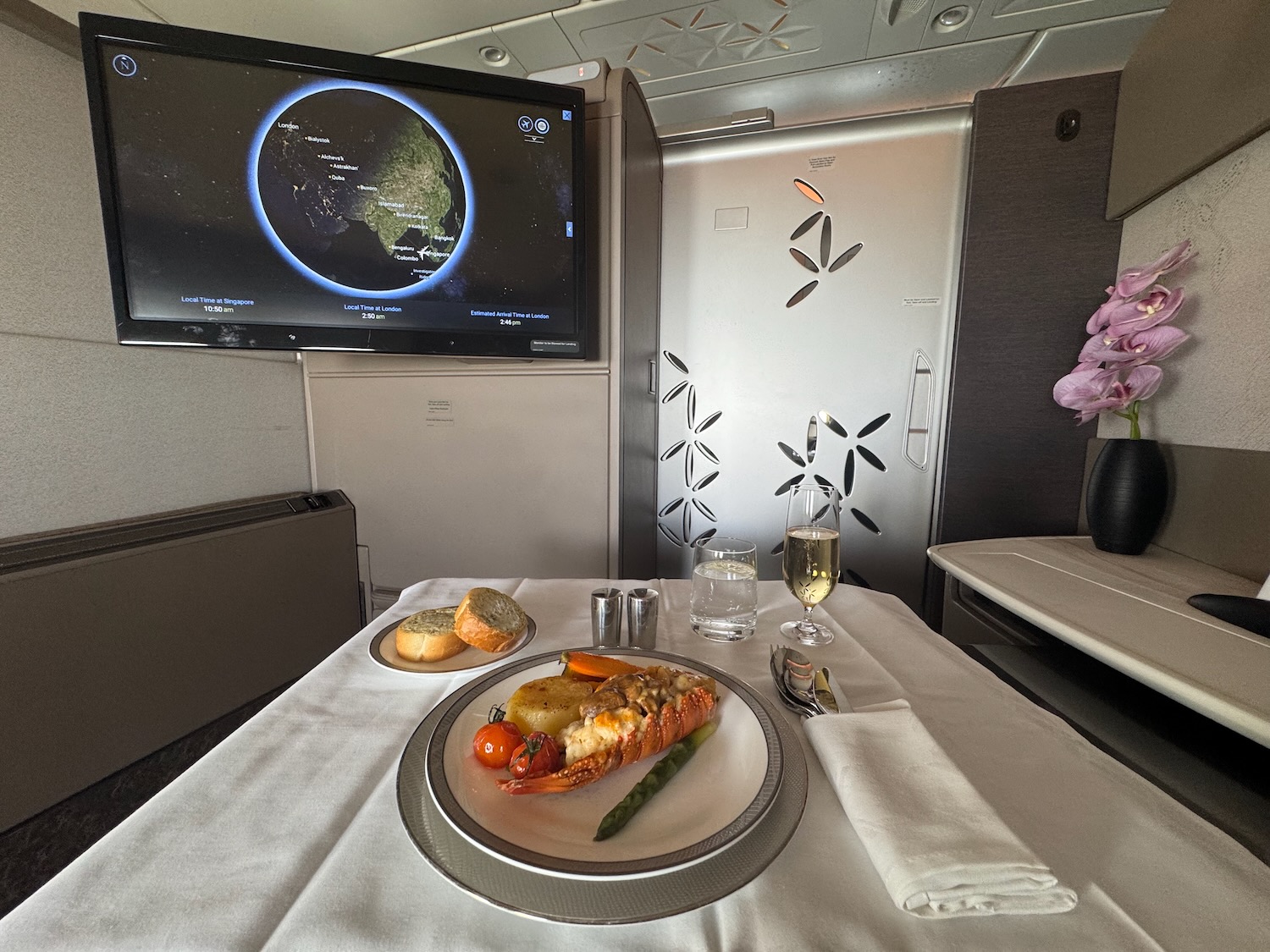 a plate of food on a table with a television on the wall