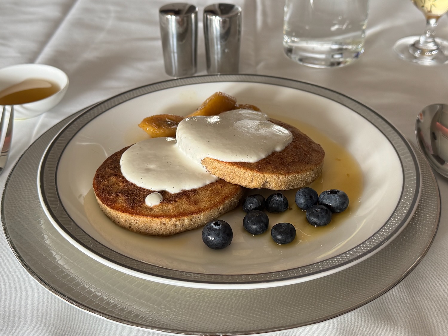 a plate of pancakes with blueberries and syrup