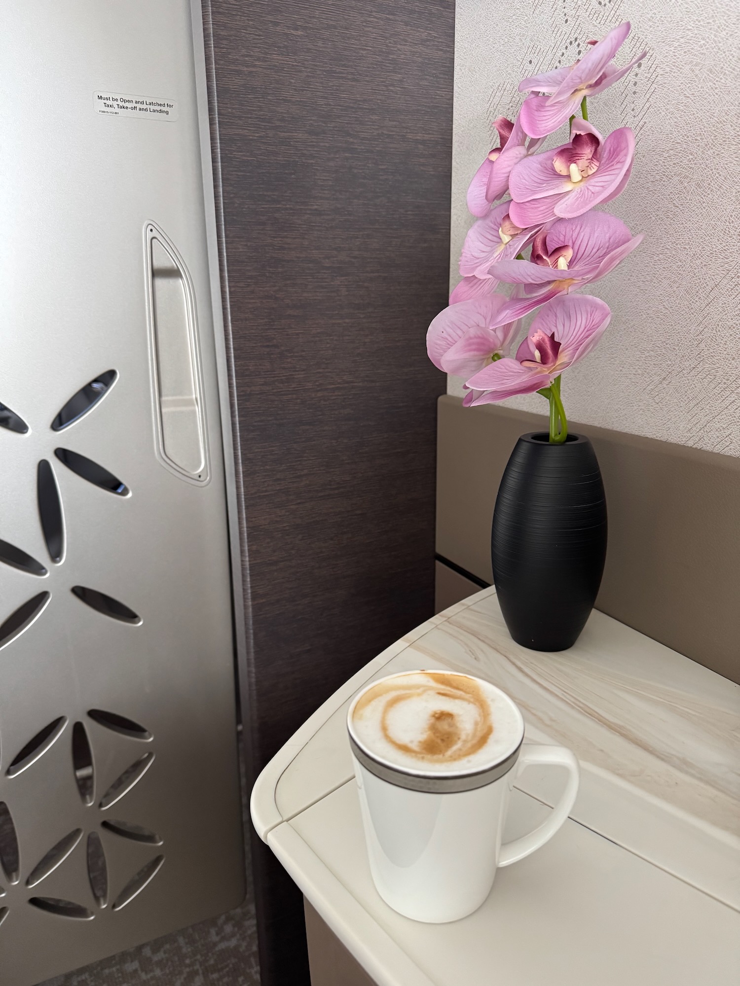 a coffee cup and a flower in a vase