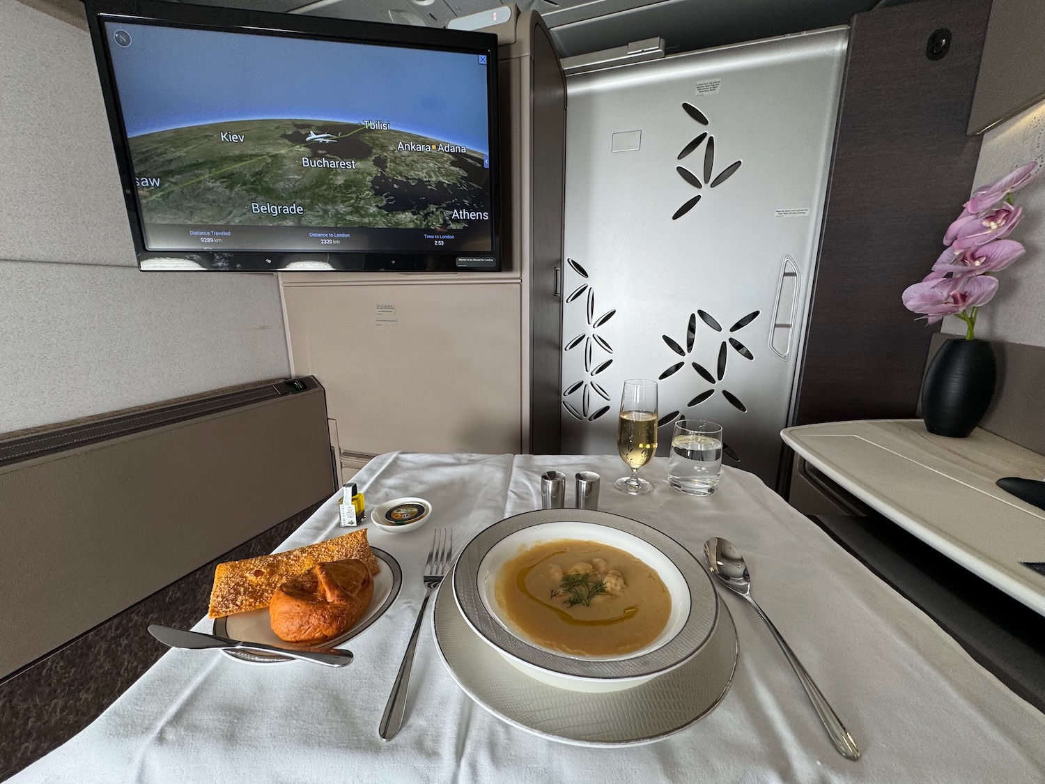a table with a plate of soup and a flat screen tv