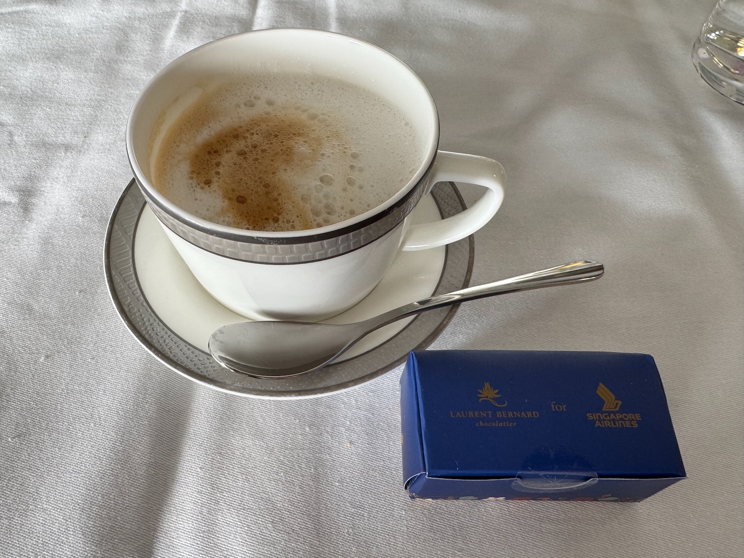 a cup of coffee with a spoon and a small box