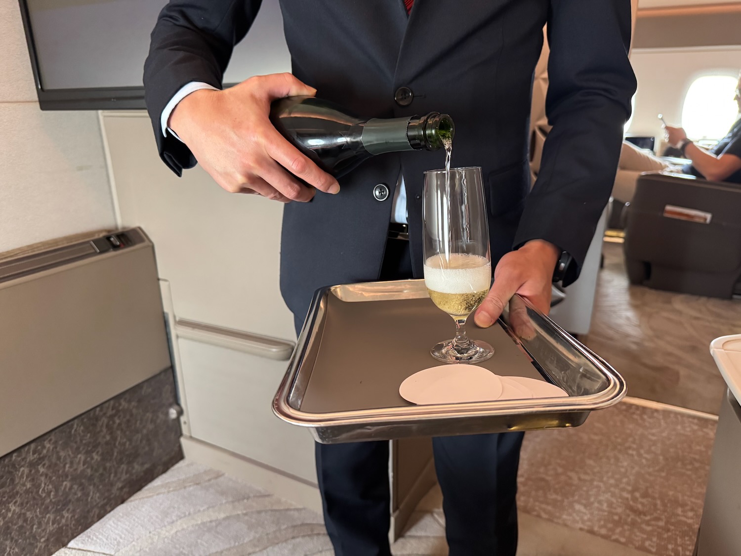 a person pouring a champagne into a glass