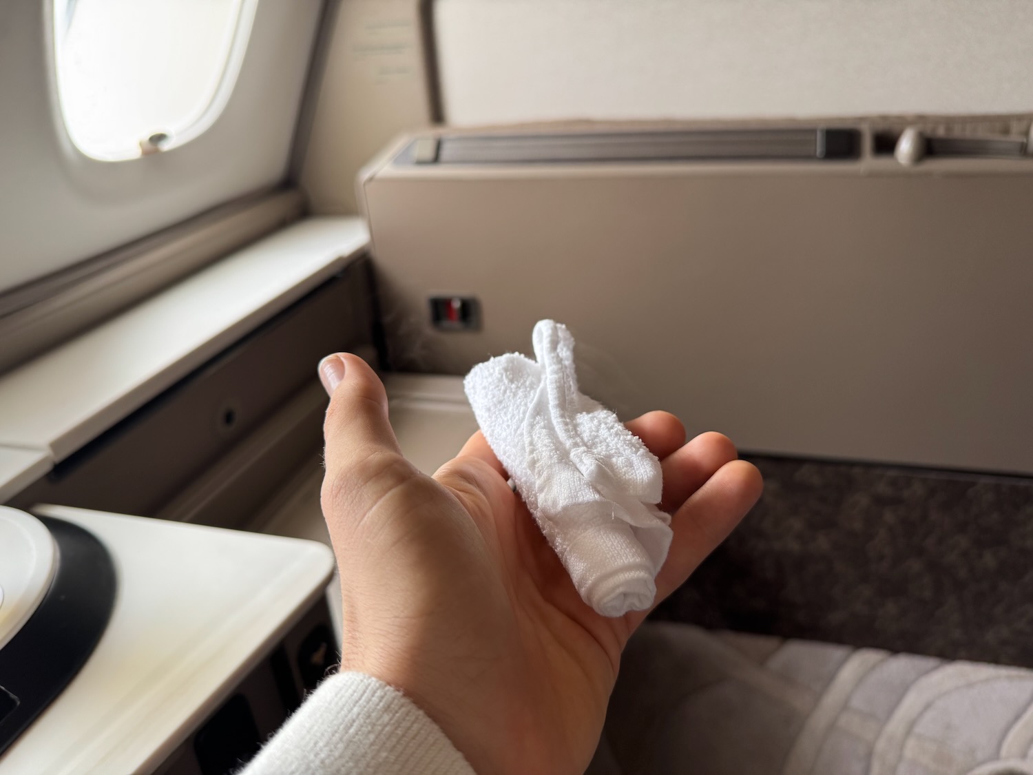 a hand holding a small white object